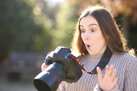 Amazed photographer checking photos on camera in winterの写真素材