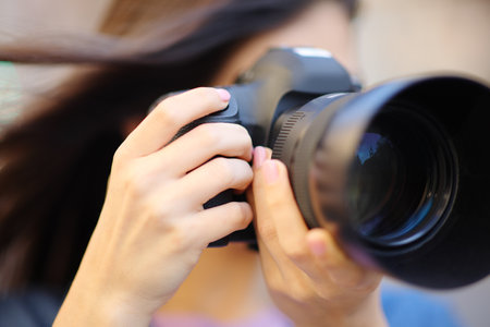 Close up of a photographer taking photos with reflex camera outdoorsの写真素材
