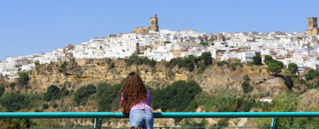 Back view portrait of a tourist contemplating town views on summer vacationの写真素材