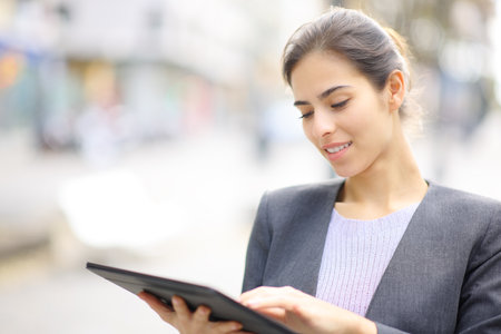 Executive using tablet standing in the streetの写真素材
