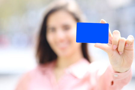 Close up portrait of an elegant woman hand showing black credit card mock up in the streetの写真素材