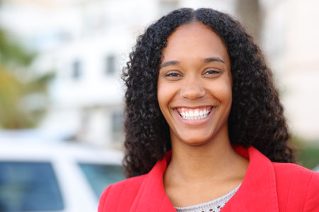 Front view portrait of a happy black woman with perfect smile in winterの写真素材