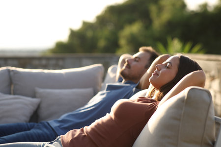 Relaxed couple resting sitting in an exterior sofa in a terraceの写真素材