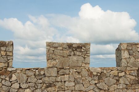 The stone wall with the blue sky backgroundの写真素材