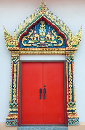 The golden carve door with red leaf in the thai templeの写真素材
