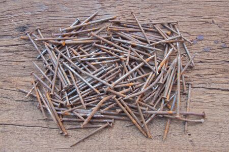 The rusty steel nail on the wood backgroundの写真素材