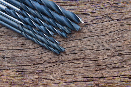 The closeup of many iron drill bit on the wood backgroundの写真素材