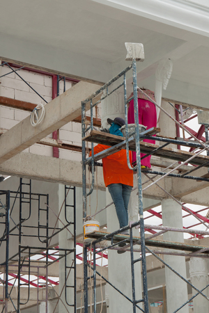 Painter painting the color on the scaffoldの写真素材