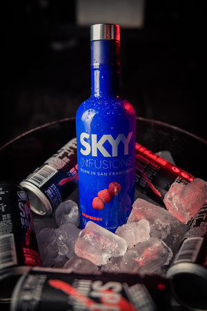 Bottle of Skyy brand raspberry flavored vodka in a bucket with ice and accompanied by cans of speed brand energy drink.のeditorial素材