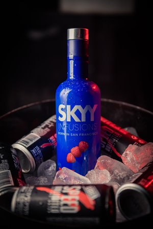 Bottle of Skyy brand raspberry flavored vodka in a bucket with ice and accompanied by cans of speed brand energy drink.のeditorial素材