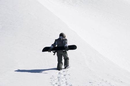 snowboarder is walking in the mountainの写真素材