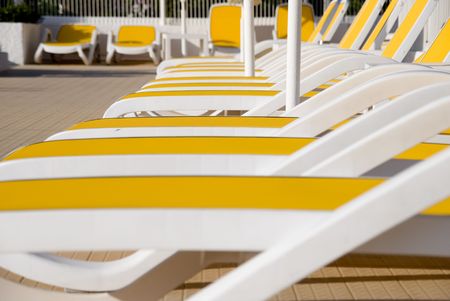 yellow chairs along the swimming pool in a resortの写真素材