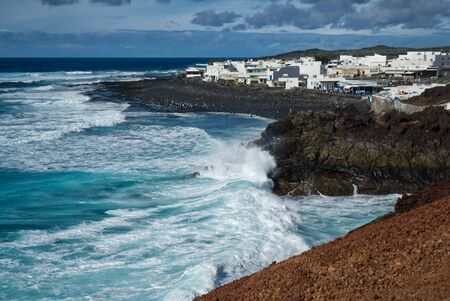 LANZAROTE, SPAIN, El Golfo, The Gulf is a lagoon in a volcanic crater surrounded by steep cliffs, nice day but rough seaの写真素材