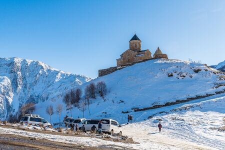 Gergeti Trinity Church and a group of tourist minivan drivers, Kazbegi, Georgiaのeditorial素材