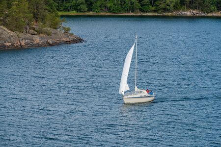 RIVER AND ROCKY COAST, SWEDEN - July 7, 2018 : A private sailboat sail along the archipelago coast of swedenのeditorial素材