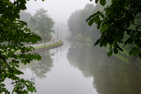Walking path next to Snelli pond with the morning mist in Toompark, Tallinn, Estoniaの写真素材