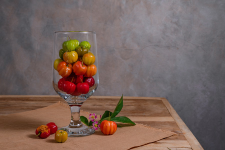 The colorful Surinam cherries in a glass on a plate matの写真素材
