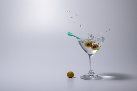 Splashing Martini cocktail liquor drink with the pickled oliveの写真素材