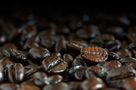 Dark brown roasted coffee beans under natural light for backgroundの写真素材