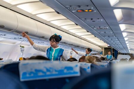 SUVARNABHUMI AIRPORT, BANGKOK, THAILAND - MARCH 23, 2019 : Flight attendants demonstrate the proper use of oxygen masks before flightのeditorial素材