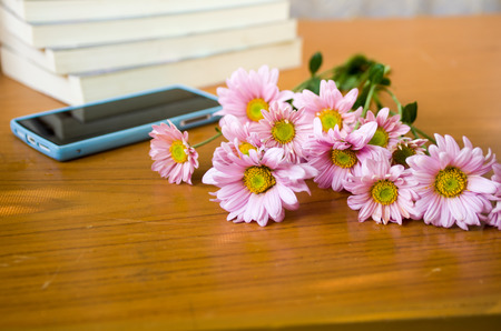 pink flower and smartphone on tableの写真素材