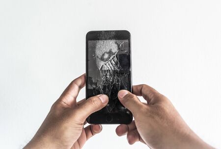 Man hand holding mobile phone with broken screenの写真素材