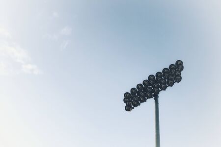Spotlight against the sky. High spotlight post against clear blue sky background. Lamp post. Street light.の写真素材
