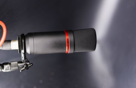 Sound studio. Microphone with cable isolated on black backgroundの写真素材