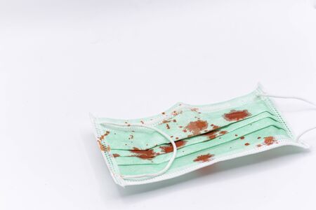 Dirty mask already using Used and dirty blood mask on a white background.の写真素材