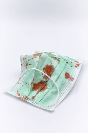 Dirty mask already using Used and dirty blood mask on a white background.の写真素材