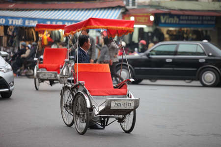 Traditional cyclo ride down the streets of Hanoi, Vietnam. The cyclo is a three-wheel bicycle taxi that appeared in Vietnam during the French colonial period.,September 19 2019のeditorial素材