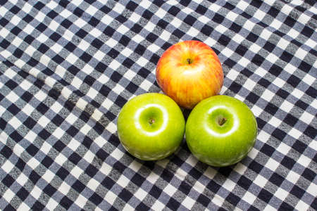 photo of an Organic apple on checkered tableclothの写真素材