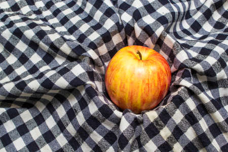 photo of an Organic apple on checkered tableclothの写真素材