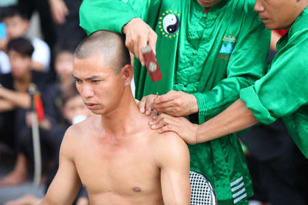 Hanoi, Vietnam - Aug 9, 2015: Vietnamese pugilists in traditional costume doing a performance of martial arts on a public and free entrance event in Hanoi capital.のeditorial素材