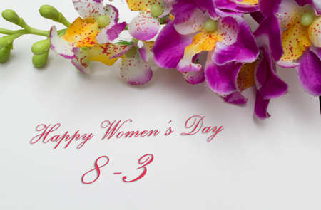 Happy Womans Day March 8th written on white card with red rosesの写真素材