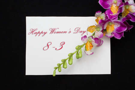 Happy Womans Day March 8th written on white card with red rosesの写真素材