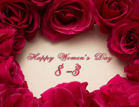 Happy Womans Day March 8th written on white card with red rosesの写真素材