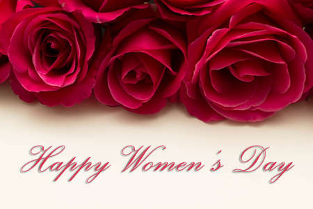 Happy Womans Day March 8th written on white card with red rosesの写真素材