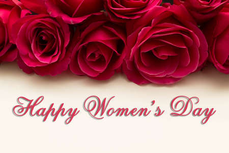 Happy Womans Day March 8th written on white card with red rosesの写真素材
