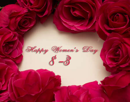 Happy Womans Day March 8th written on white card with red rosesの写真素材