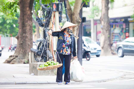 Hanoi, Vietnam - November 21, 2019: Street vendors are hurriedly cycling across the street to find customers in the small neighborhood in Hanoi, Vietnamのeditorial素材