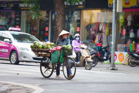 Hanoi, Vietnam - November 21, 2019: Street vendors are hurriedly cycling across the street to find customers in the small neighborhood in Hanoi, Vietnamのeditorial素材