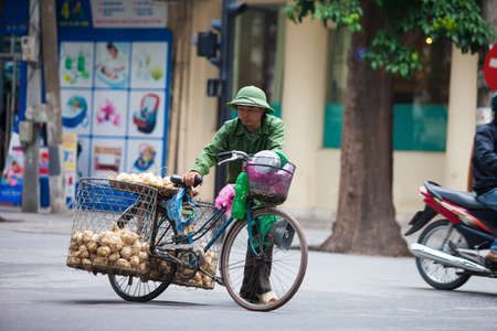 Hanoi, Vietnam - November 21, 2019: Street vendors are hurriedly cycling across the street to find customers in the small neighborhood in Hanoi, Vietnamのeditorial素材