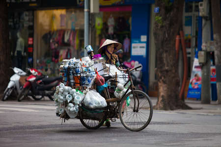 Hanoi, Vietnam - November 21, 2019: Street vendors are hurriedly cycling across the street to find customers in the small neighborhood in Hanoi, Vietnamのeditorial素材