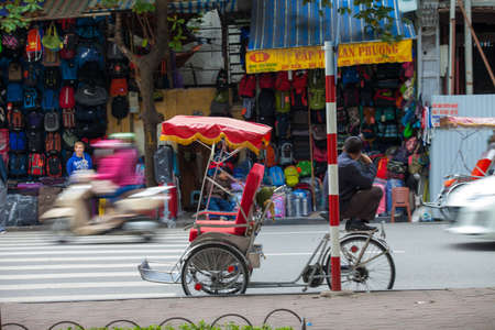 Hanoi, Vietnam - November 21, 2019: Street vendors are hurriedly cycling across the street to find customers in the small neighborhood in Hanoi, Vietnamのeditorial素材
