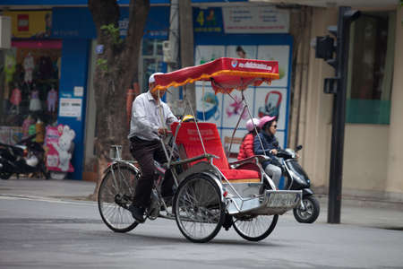 Hanoi, Vietnam - November 21, 2019: Street vendors are hurriedly cycling across the street to find customers in the small neighborhood in Hanoi, Vietnamのeditorial素材