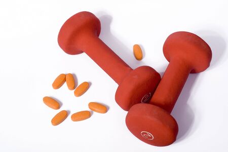 A set of dumbbells and vitamins isolated on white.の写真素材