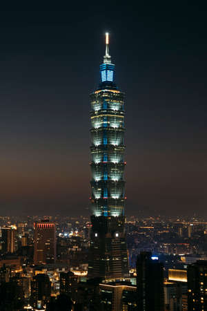 portrait view of Taipei 101 tower and cityscape at night with city lights in Taipei, Taiwan.