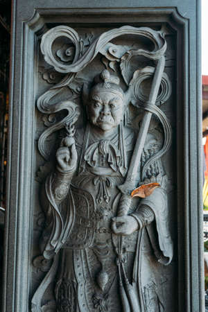 intricate stone carved buddhist figure with sword and armor at a Chih Nan temple in Taipei Taiwan,...