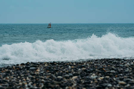 White foaming wave crashing on stony Hualien beach, Taiwan.の写真素材